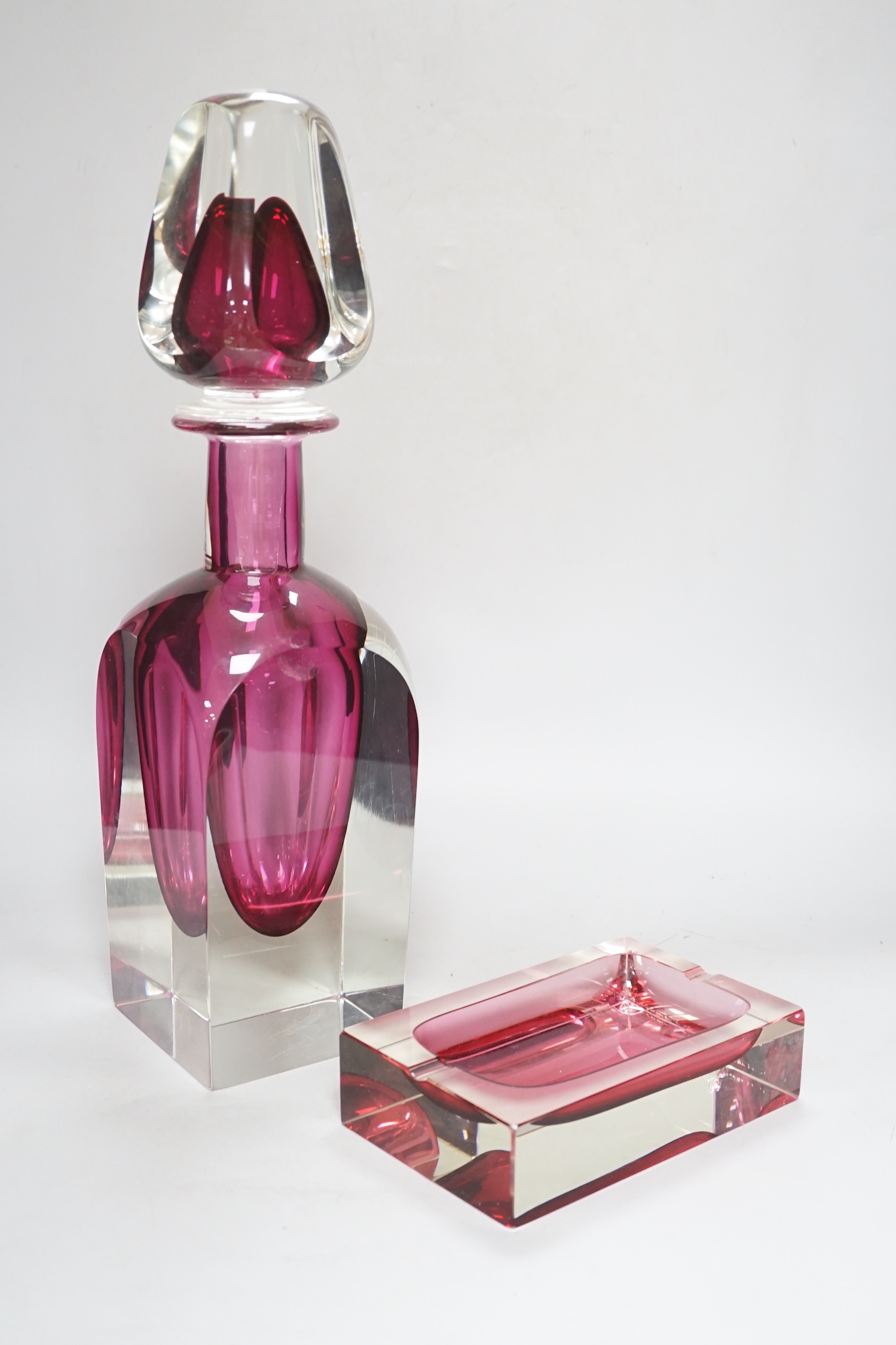 A large oversized Murano studio glass tear drop perfume bottle and a cranberry ashtray, the largest 45cm high